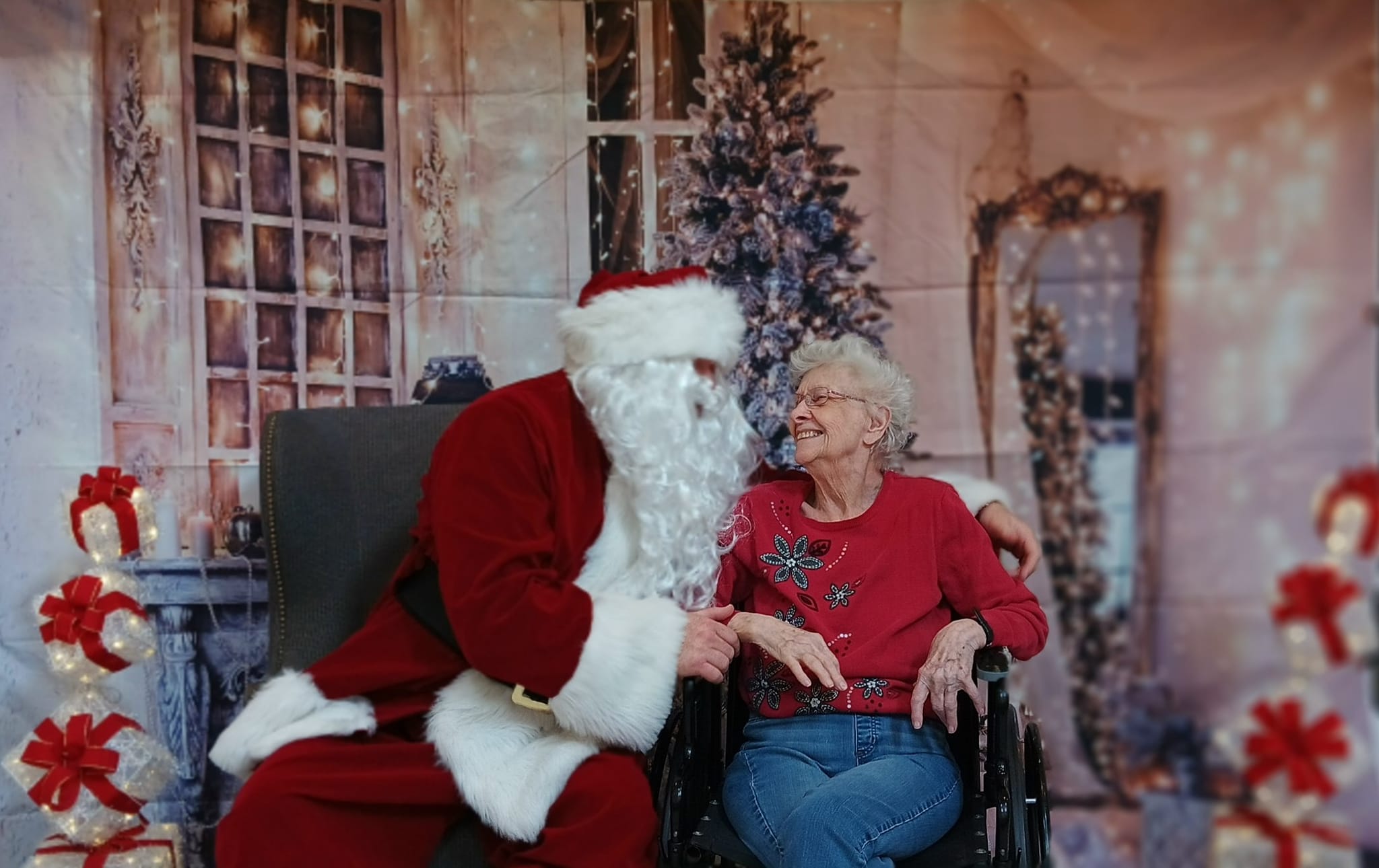 santa smiling with elderly lady in wheelchair